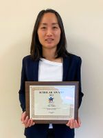 Emi Tsuda holding the young scholar award