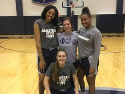Abby Reid and three Georgetown women's basketball players take photo.