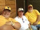 The Hayhurst family brothers seated, (from left) Robert, Ronald and Robin wearing gold and white WVU shirts and gold WVU baseball caps.