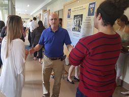 Faculty members provide feedback to students about their research posters. 