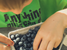Young child in a green t-shirt sifting through freshly picked blueberries.