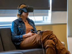 A student sits with a virtual reality headset on.