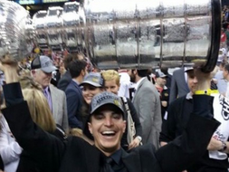 Ian Gentile in a baseball hat holding the Stanley Cup over his head.