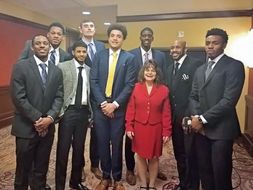 Theresa Scafella standing with members of the WVU Basketball Team