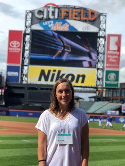 Cara Johnson in front of signage at Citi Field.